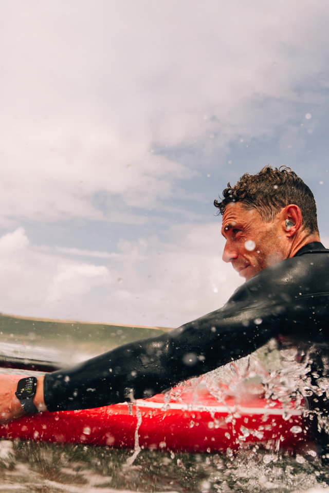 Un hombre con una tabla de paddleboard en el agua lleva puesto un Apple Watch Series 10